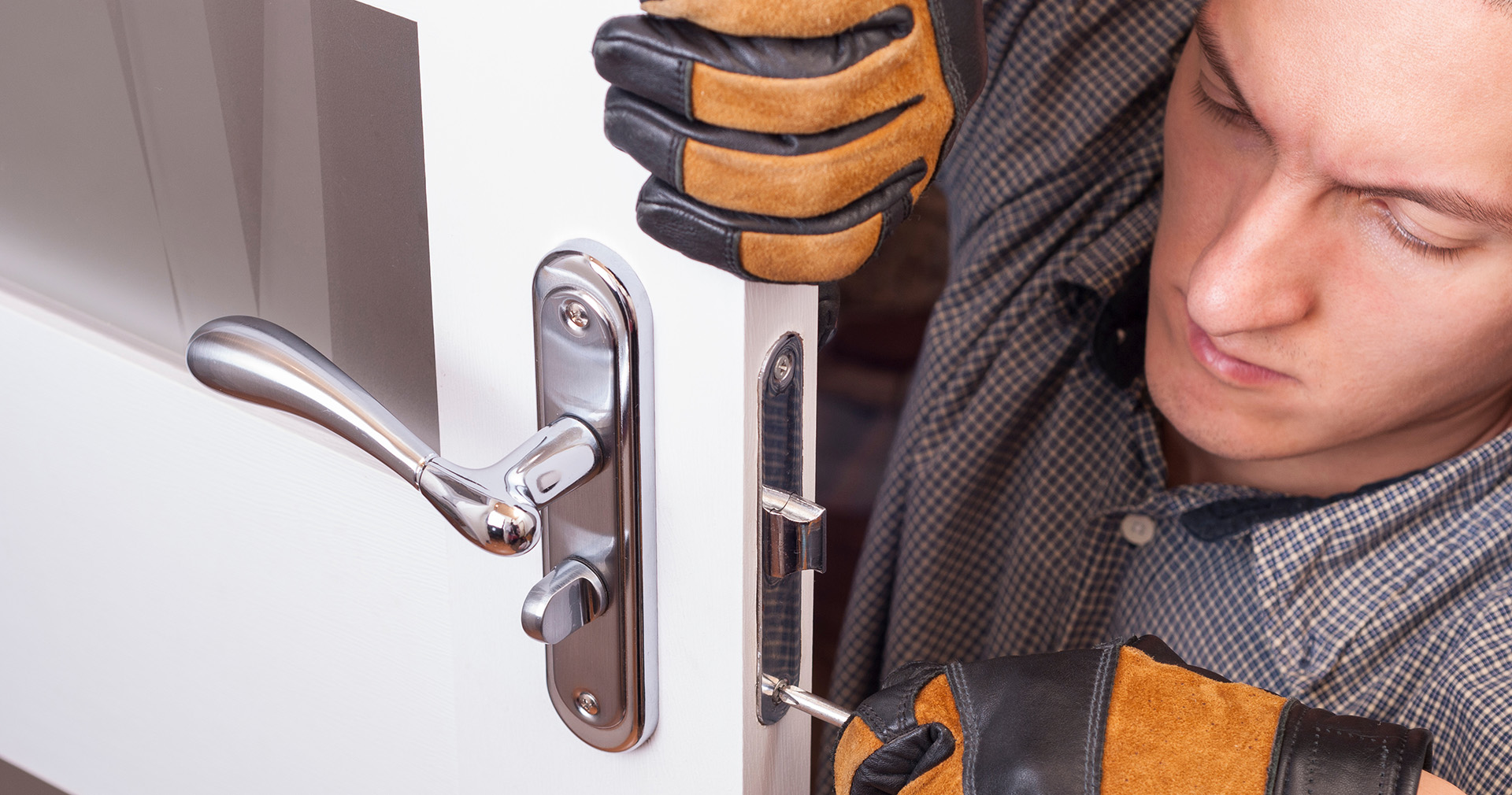 Locksmith rekeying a home's front door lock